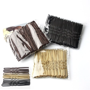 Close-up of U-shaped metal bridal hair pins in black, gold, and brown finishes
