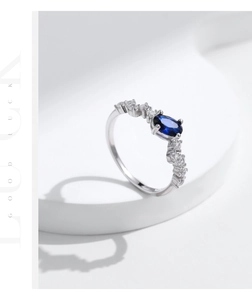 Nahaufnahme eines S925-Silberrings mit ovalem blauem Stein und seitlichen Diamanten