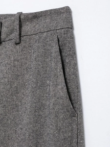 Detailed macro view of the grey textured fabric waistband and pockets on trousers