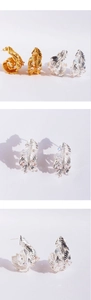 Detailed view of elegant feather earrings with sparkling cubic zirconia in gold and silver
