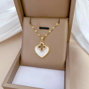 Elegant gold heart necklace with clover motif and white shell inlay in jewelry box
