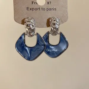 Retro geometric silver earrings with hammered metal and blue marbled resin pendant