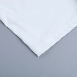 Close-up of white elegant dress hem showing high-quality double-needle stitching detail