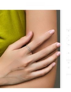 Detail of s925 silver moissanite eternity ring worn against a bright green fabric background