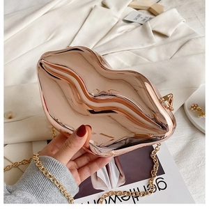 Detail of creative lip-shaped metal evening clutch in rose gold with elegant chain strap