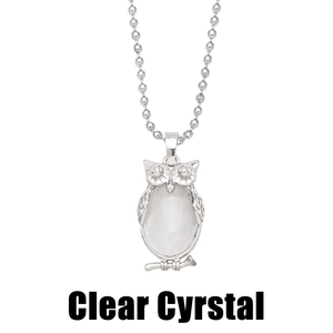 Detail of silver owl pendant with clear crystal center on a sleek ball chain link