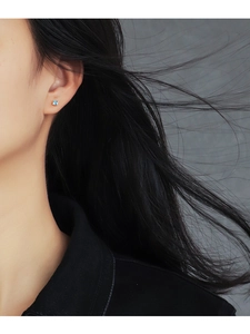 Close-up of minimalist square blue zircon stud earring worn by a model on the earlobe