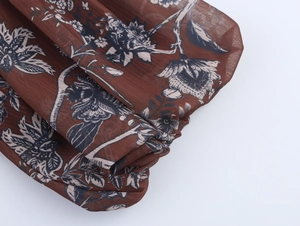 Close-up of vintage floral print chiffon fabric with dark brown botanical pattern