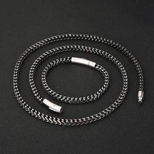Close-up of titanium steel wheat chain necklace and bracelet with cylindrical clasp