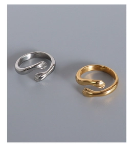 Detailed view of hugging hands open rings in polished gold and silver finishes