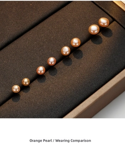 Macro shot of eight natural orange-pink freshwater pearls on a textured jewelry tray