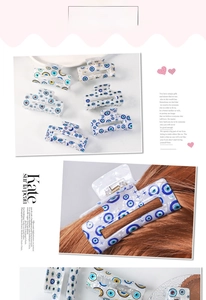 Detail of bohemian evil eye hair claws with gold star and moon patterns on long hair