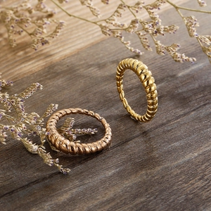 Polished gold and rose gold croissant rings featuring a textured twisted design