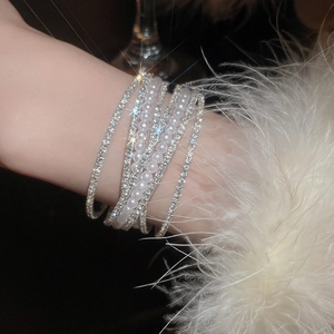 Detail of elegant multi-layer pearl and rhinestone crossover bracelet on wrist