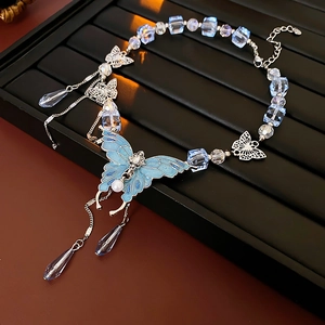 Détail du collier pendentif papillon en cristal bleu avec franges sur plateau à bijoux