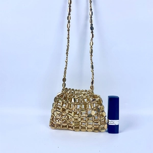 Detail of a handmade gold beaded mini bag featuring an intricate woven mesh pattern