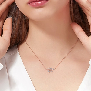 Rose gold leaf pendant necklace with D color moissanite on a model for elegant look