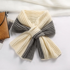 Détail d'une écharpe en maille bicolore beige et gris montrant la texture côtelée et le nœud