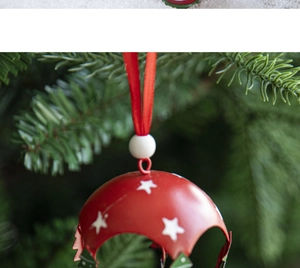 Close-up of red Christmas hot air balloon ornament with white stars on pine branches
