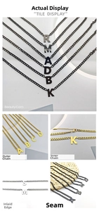 Detail view of hip hop capital letter pendants in gold, silver, and black on curb chains
