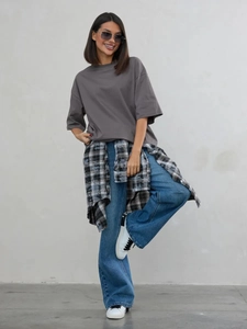 Vista completa di t-shirt casual in cotone grigio scuro abbinata a jeans blu larghi