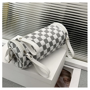 Close-up of checkerboard cylinder bag showing textured pleats and silver hardware