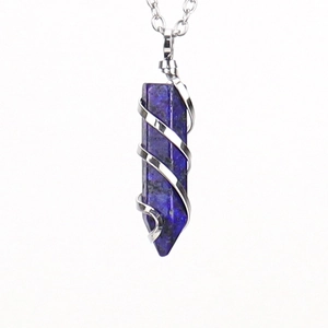 Macro view of natural lapis lazuli hex crystal pendant with silver wire wrap