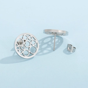 Macro shot of silver hollow circular stud earrings with push-back closures on blue background