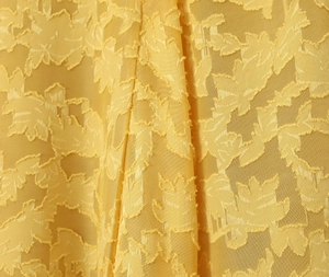 Makroaufnahme von gelbem Ausbrenner-Stoff mit detaillierter Blatt-Stickerei-Textur