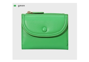 Detalle de la cartera verde de cuero con botón de presión y cremallera dorada