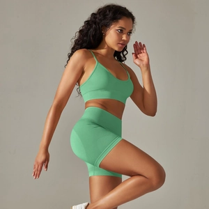 Detail von grünem Yoga-Set mit rückenfreiem Sport-BH und enger Shorts aus elastischem Strick