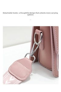 Close-up of pink leather handbag showing detachable silver metal hook and woven strap