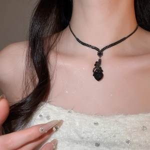 Detail of elegant black gemstone heart pendant necklace worn by female model
