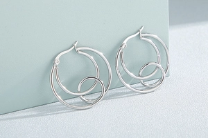 Macro shot of silver stainless steel double hoop earrings with a modern nested design