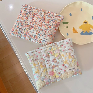 Quilted floral makeup bag with simple wish label shown on a cream surface