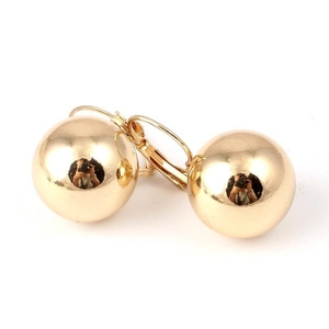 Detailed view of polished gold sphere drop earrings with lever-back closure on white background