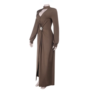 Détail du décolleté plongeant en V et de la boucle en métal sur la robe longue marron