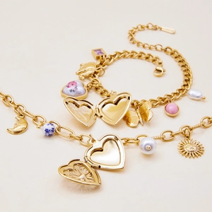 Detailed view of gold-plated multi-pendant bracelet with heart locket and pearls