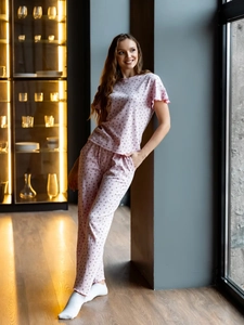 Détail du pyjama rose avec imprimés cœurs et volants aux poignets sur tricot doux