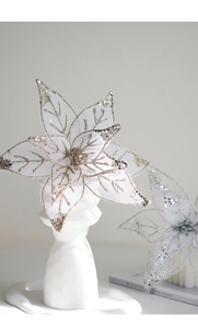 Detailed view of white mesh Christmas flower with gold sequins on ceramic stand