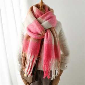 Detail of pink plaid scarf with soft fringe tassels and thick warm cashmere-like texture