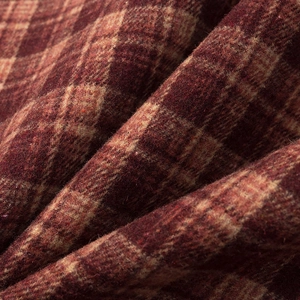 Détail de la texture d'un tissu en laine épais à carreaux rouge-brun et beige