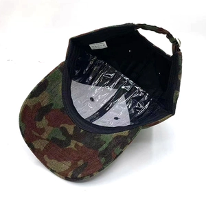Macro view of camo baseball cap interior showing 100% cotton label and adjustable metal buckle