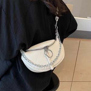 Minimalist white half-moon crossbody bag with bold silver metal chain and leather texture