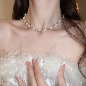 Dettaglio dell'elegante collana d'oro con perla e pendente a fiore di diamante