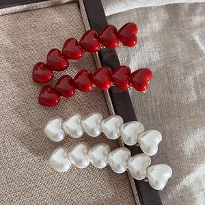 Elegant red and pearl white heart-shaped hair clips with gold finish duckbill clips