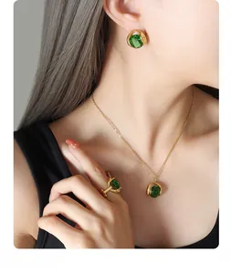 Detail shot of vintage emerald crystal pendant necklace and earrings set on model