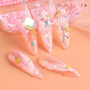 Detail of pink pointed nails with gold stars, aurora gems and iridescent sequins