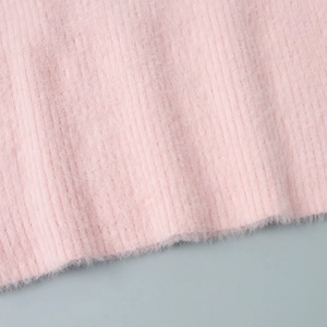 Detailed close-up of soft pink fuzzy knit fabric and vertical ribbed texture on a mini dress