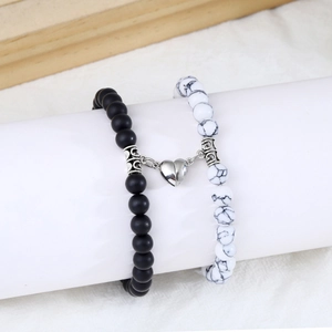 Detail showing magnetic heart clasp and texture of matte black and white marble beads